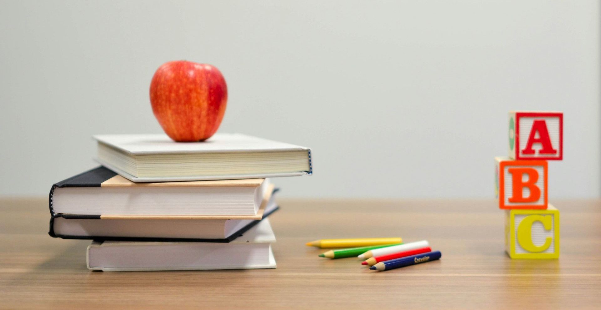 red apple fruit on four pyle books